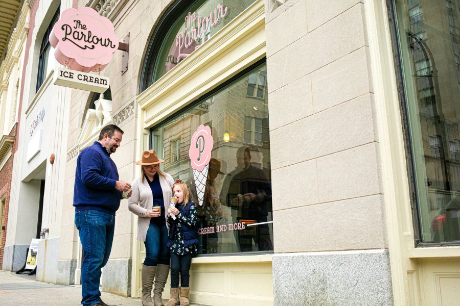 A couple enjoy ice cream with their daughter outside of The Parlour in Durham, NC.