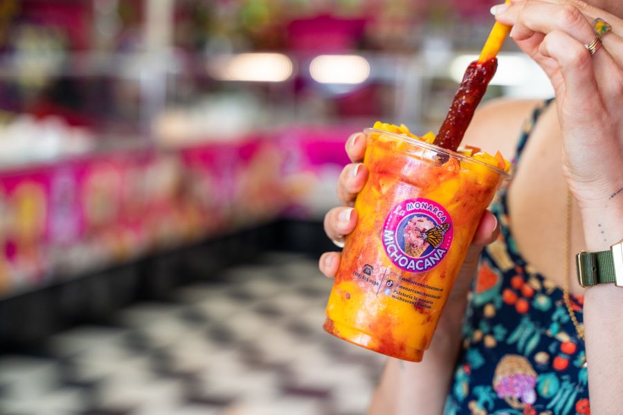 A customer sips a colorful frozen treat at La Monarca Michoacana in Durham, NC