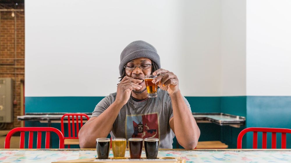 A customer savors a flight of seasonal beers at Fullsteam Brewery in Durham, NC