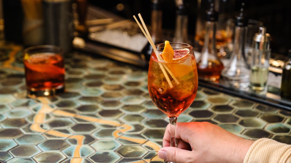 A customer holds a drink to the table at Kingfisher in Durham, NC.
