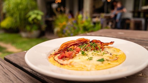 A bacon and grits bowl from ﻿Foster's Market in Durham foregrounds the storefront.