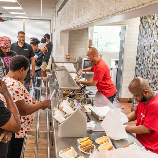 Employees at Chicken Hut serve customers in a busy store.