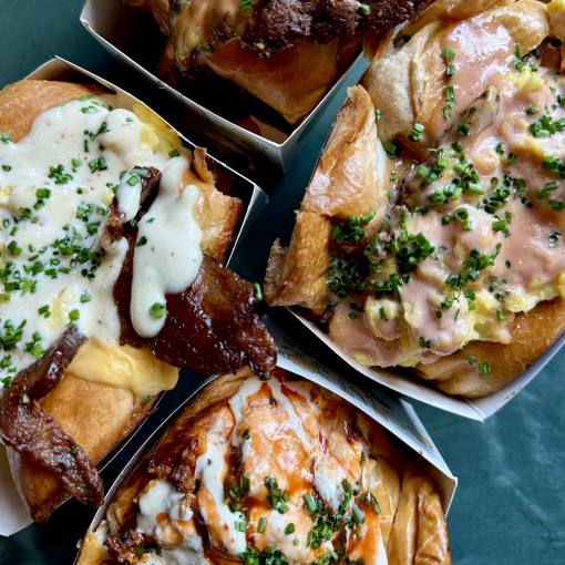 Four colorful, saucy dishes sit on a table at Aaktun in Durham, NC.