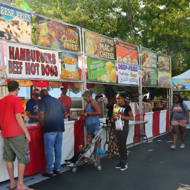 Festival goers line up to get fair food at a stand at CenterFest.