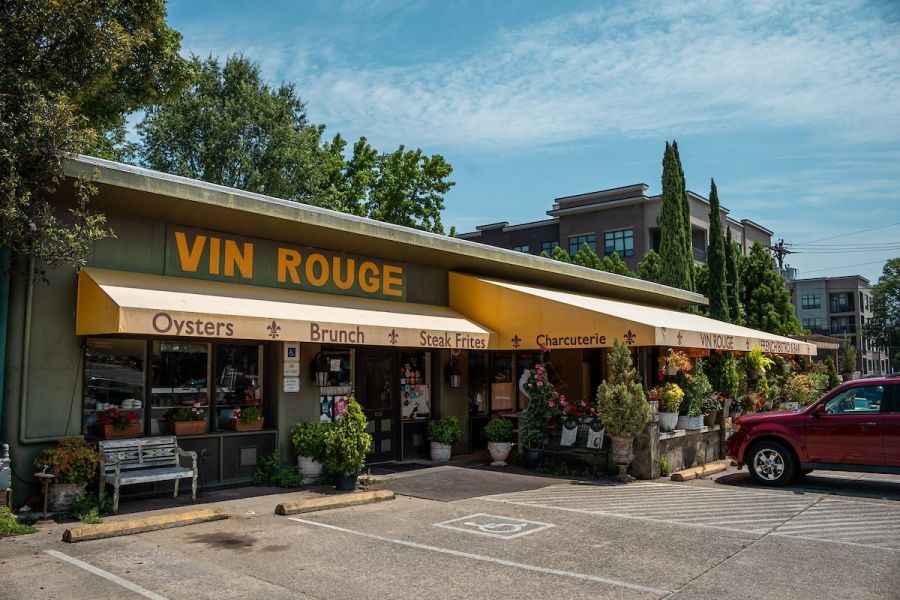 The olive colored storefront of Vin Rogue is tucked away on the street corner on a sunny day.