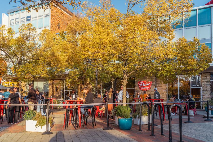 Customers enjoy drinks and food on the patio at Pour Taproom on a sunny, early fall day.