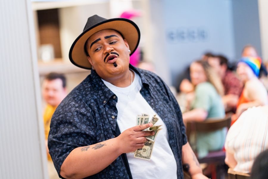 Eventgoers look on as a drag performer walks at House of Coxx Drag Brunch.