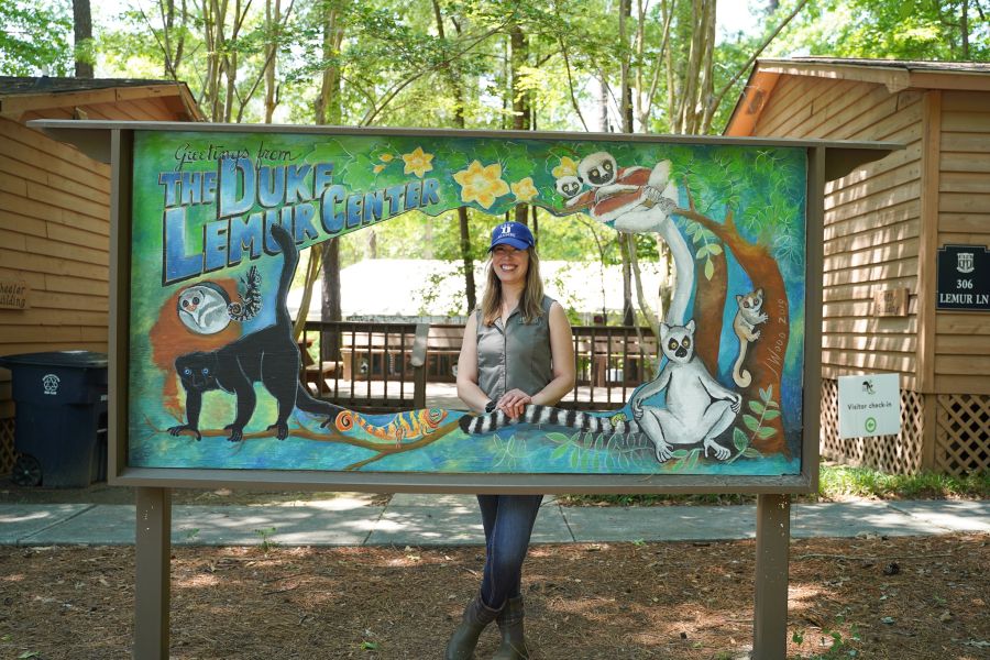 An employee stands behind a sign at the Duke Lemur Center in Durham, NC.