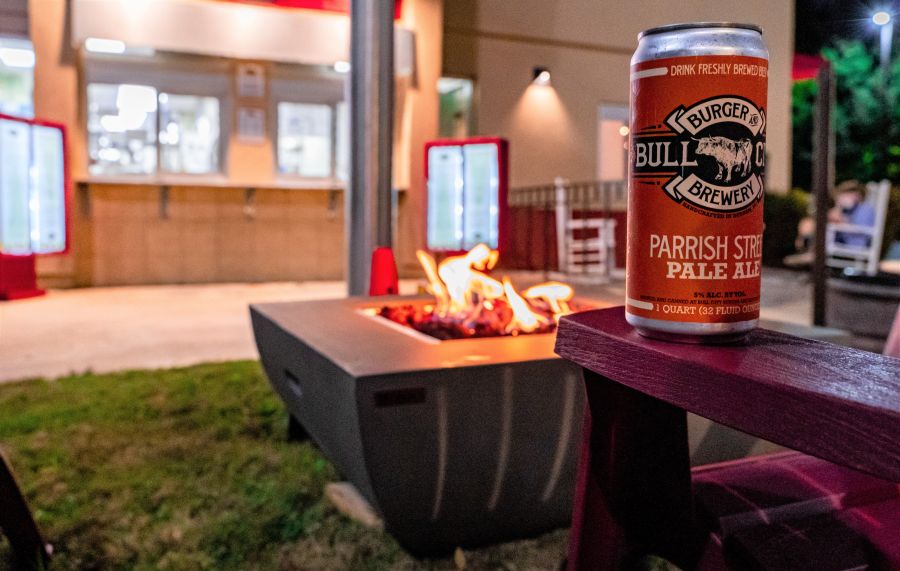 A beer sits on a table by a fire pit on the patio at Bull City Solera.