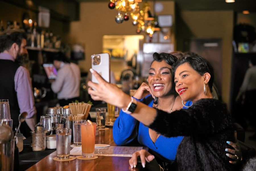Two women take a selfie before enjoying their cocktails at the bar at Alley Twenty Six.