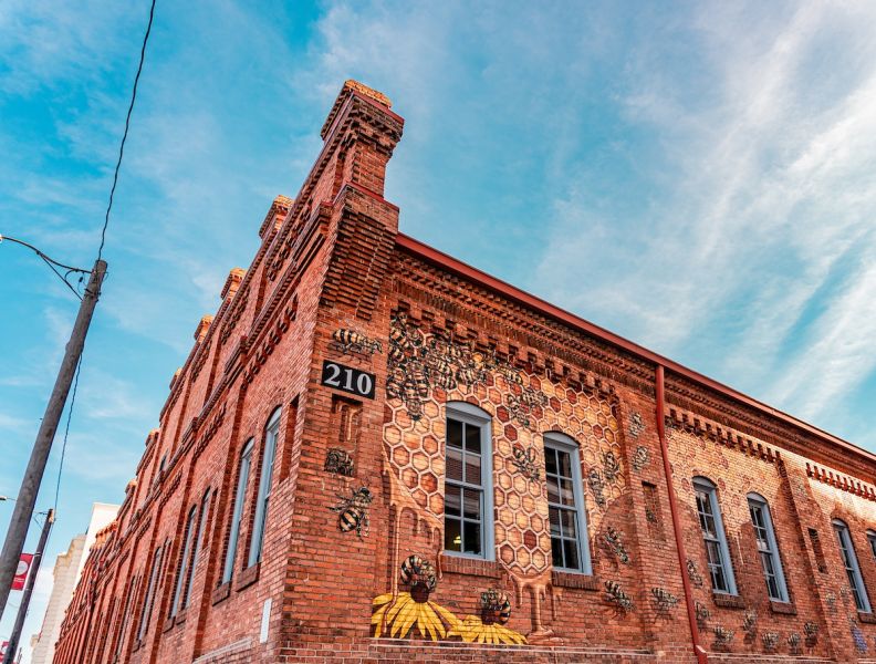 Clouds streak across the sky above the Burt's Bees "Swarm" mural by artist Matthew Willey.