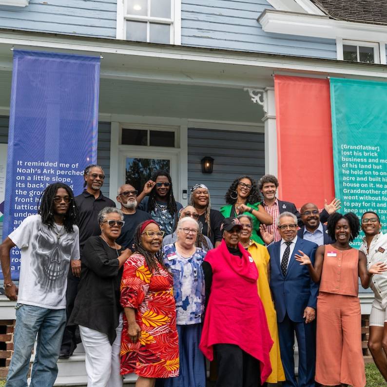 A crowd of people pose for the camera in front of the Pauli Murray Center in Durham, NC