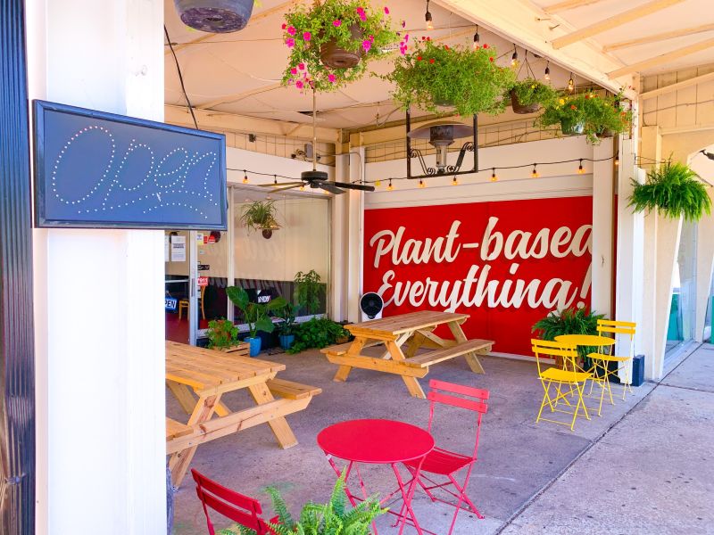 Potted plants hang over picnic tables on the patio at Pure Soul.