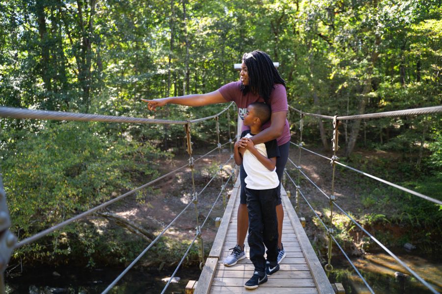A mother and child view nature on the suspension bridge at Eno River State Park.
