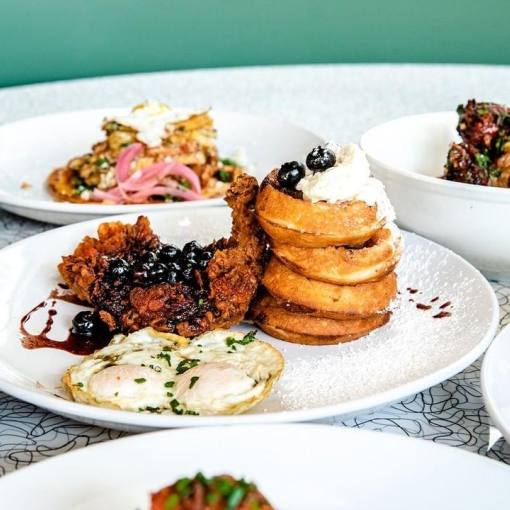 Brunch plates surround a centerpiece of eggs and waffles from True Flavors.