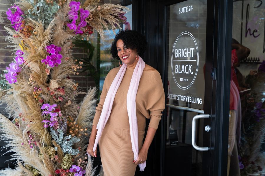 Tiffany Griffin poses outside the new storefront of Bright Black Candles on the day of the ribbon cutting.