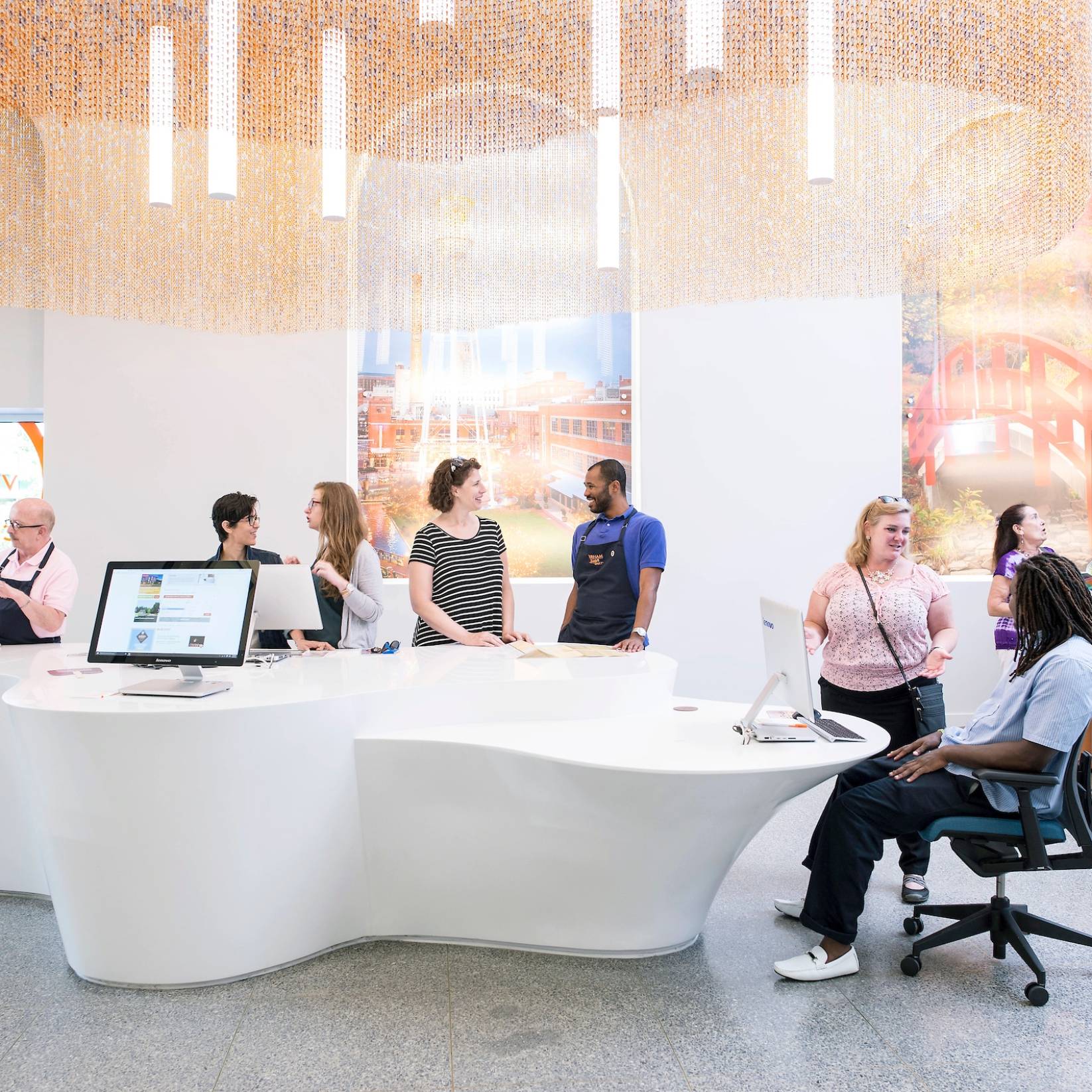 People gather around a white table in a bright, modern space at the Visitor Info Center in Durham, NC.