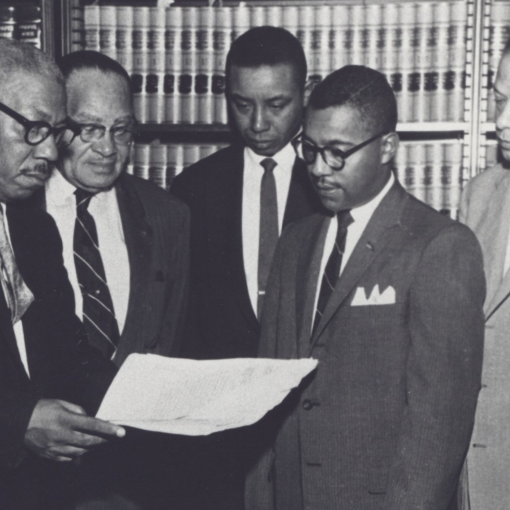 Judge Floyd McKissick stands in a black and white photo with other men.